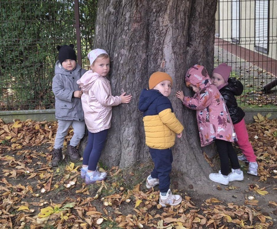 Dzieci stojące koło drzewa