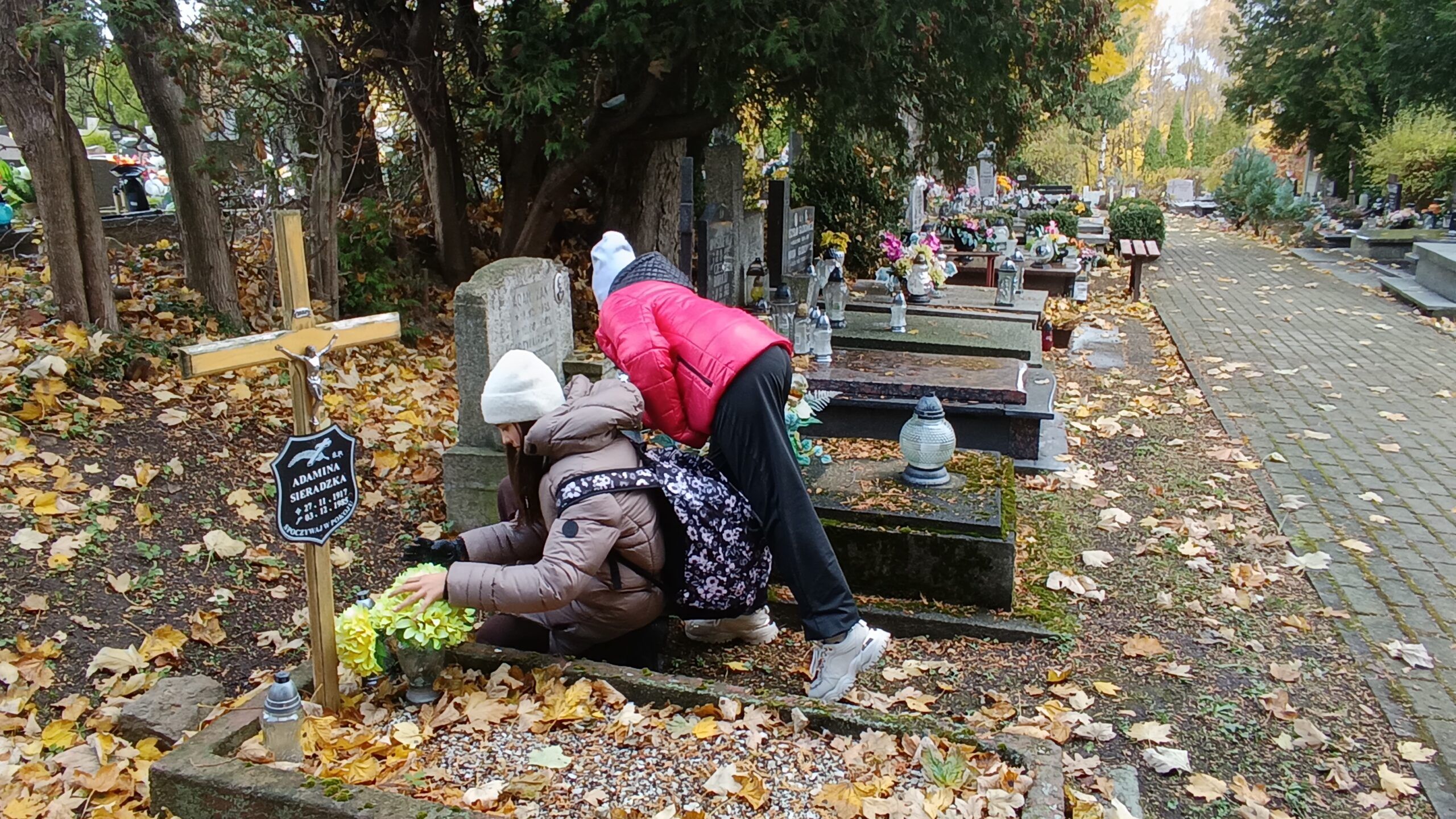 Uczniowie chodzący po cmentarzu
