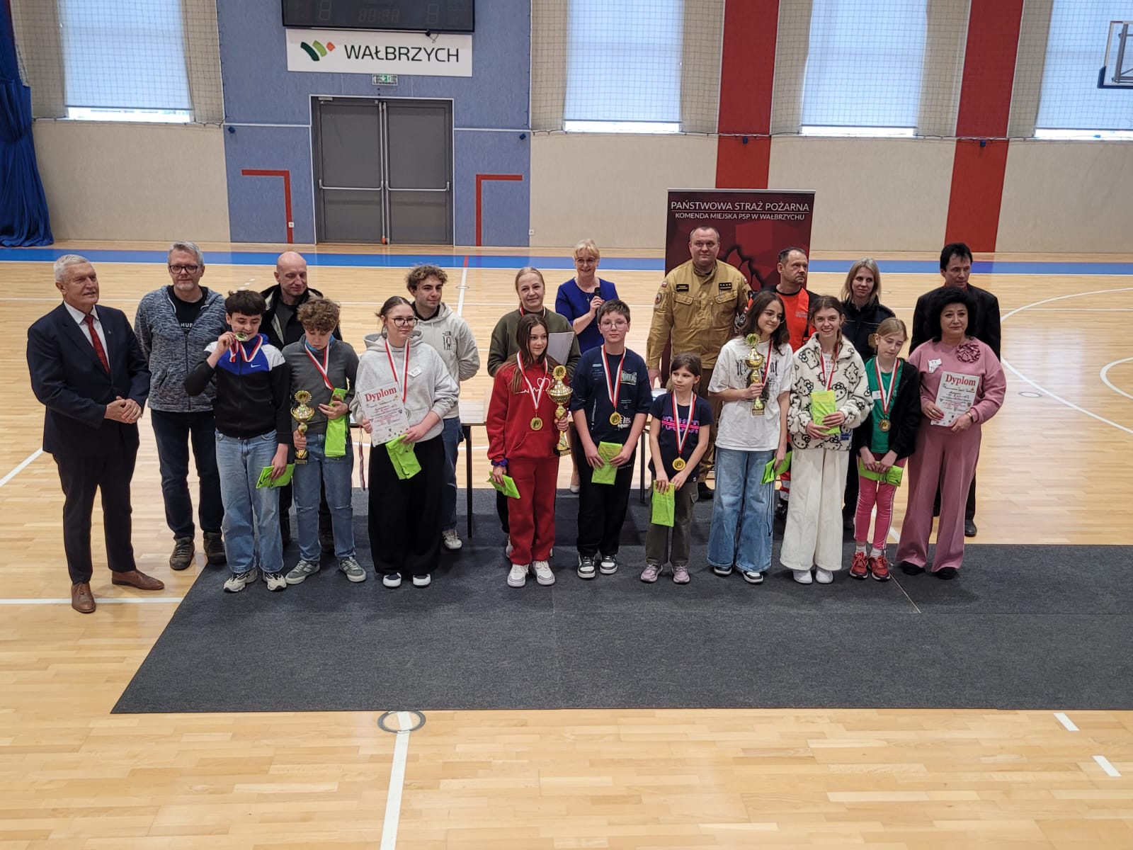 uczniowie odbierają dyplomy i puchary